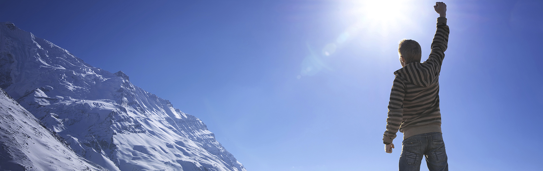 Man Facing Mountain with Arm Raised in a Fist